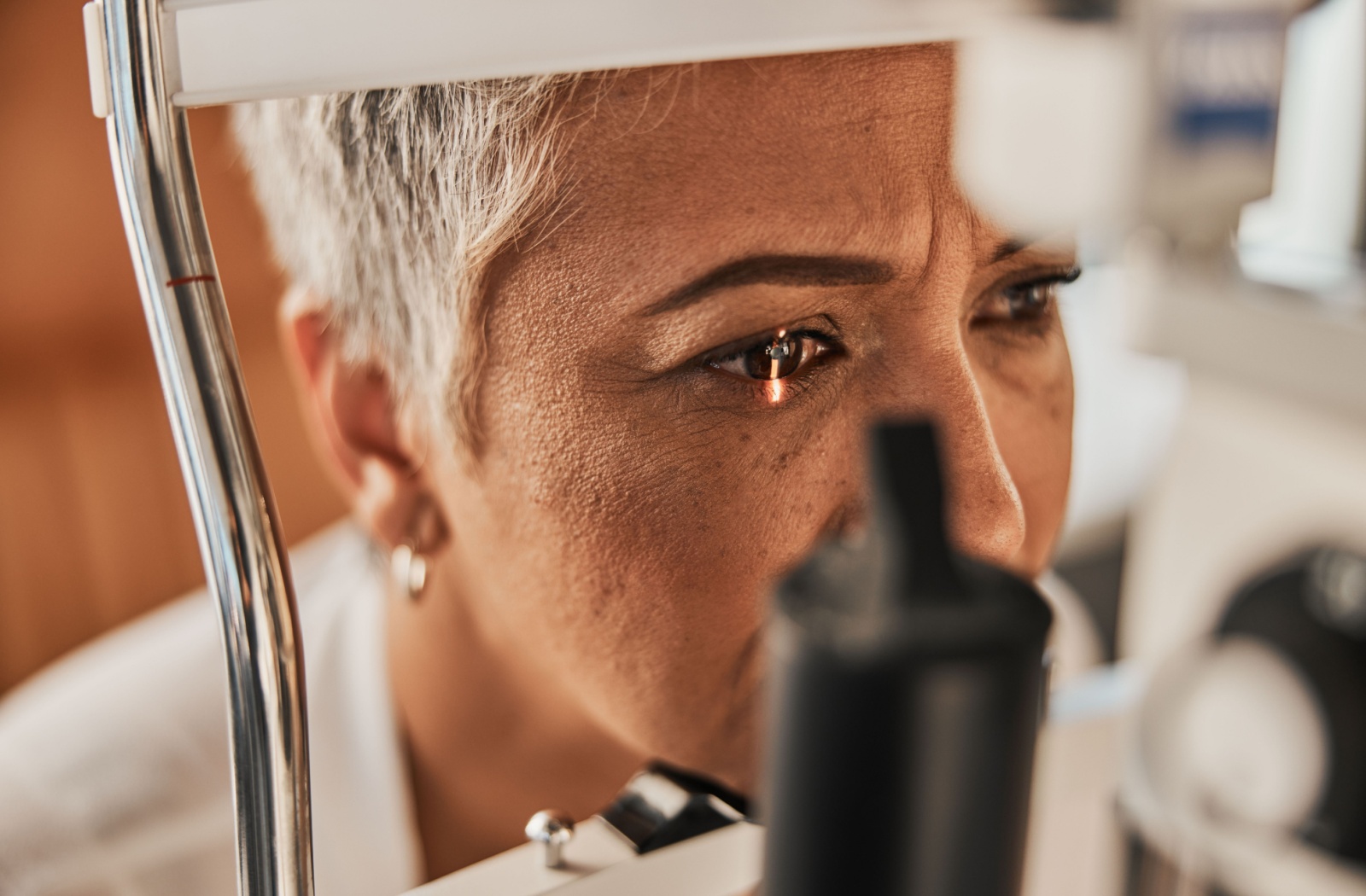 A senior woman in a slit-lamp test during her regular comprehensive eye exam.