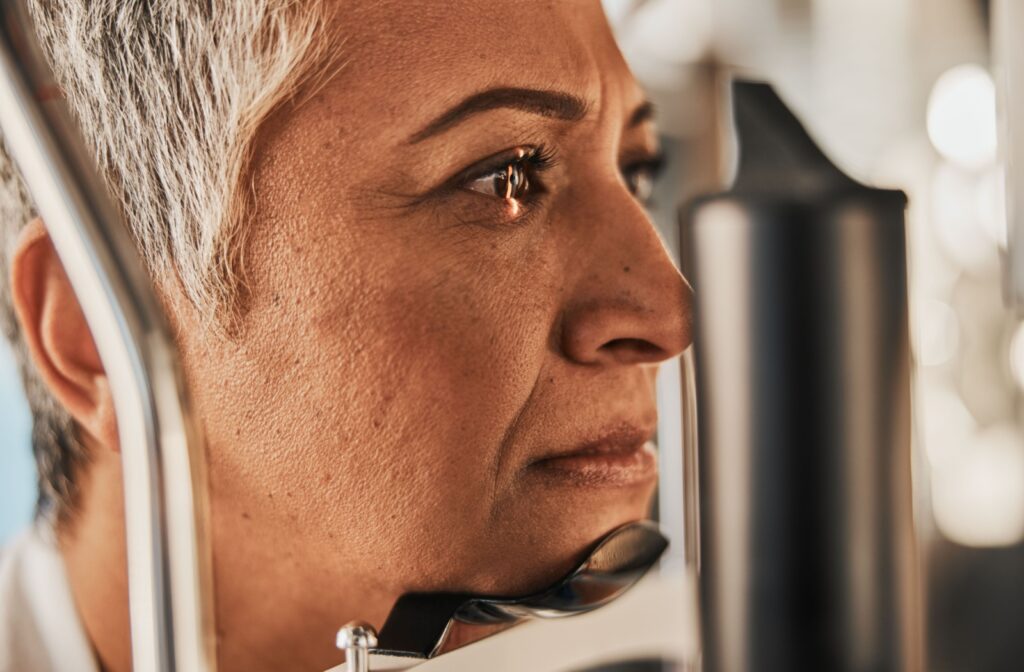 A close-up image of an older adult undergoing an eye exam to diagnose the early warning signs of macular degeneration.