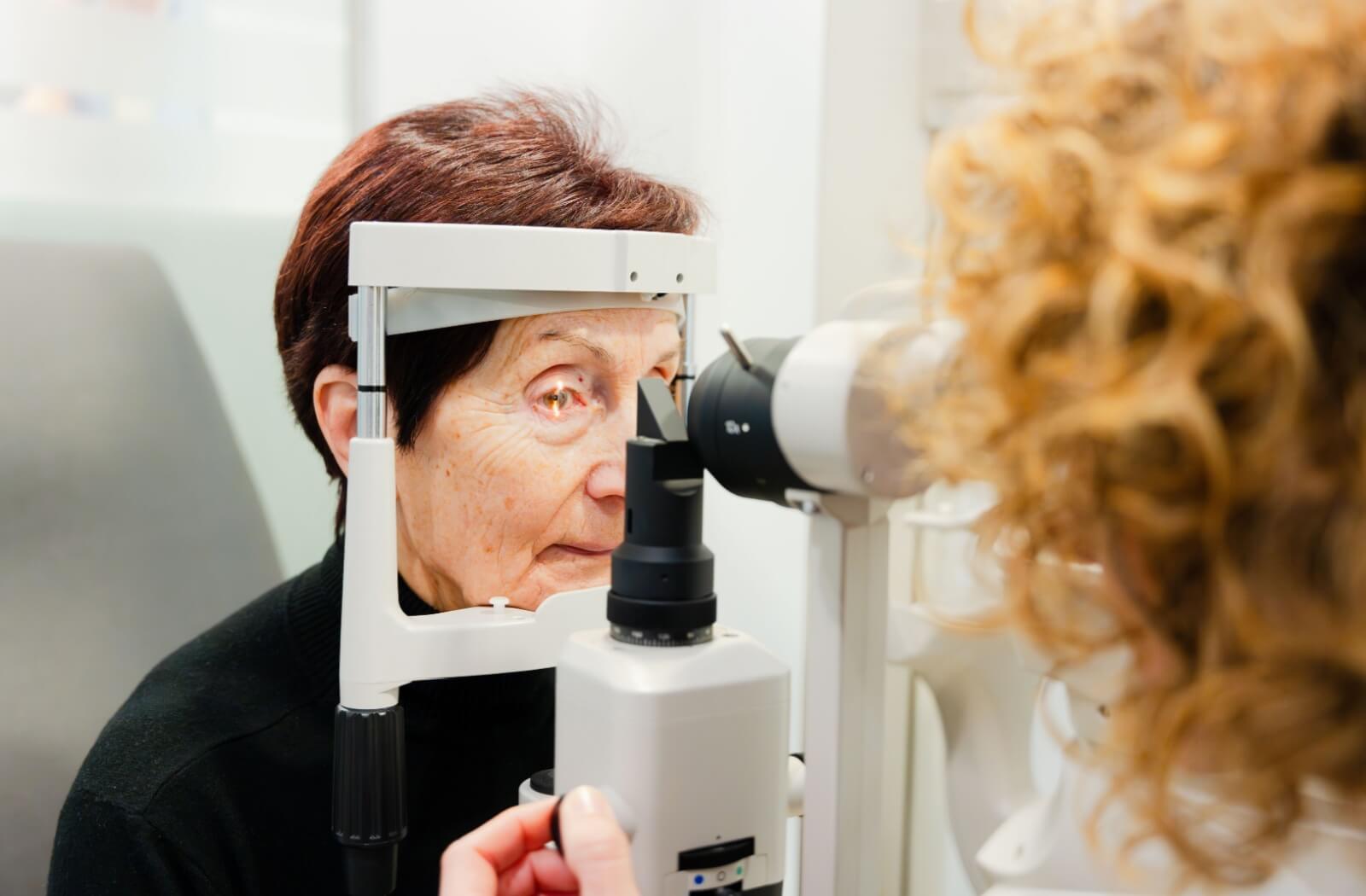 A senior undergoes a slit lamp examination to determine if they have a cataract.