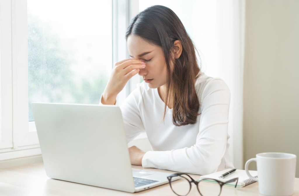 Person experiencing eye strain from not wearing their glasses